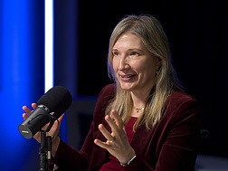 a person sitting at a desk with a microphone