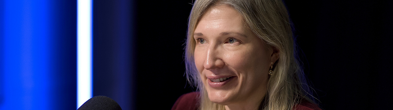 a person sitting at a desk with a microphone