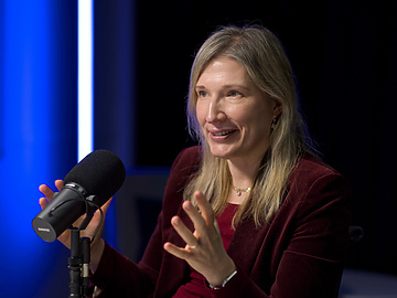a person sitting at a desk with a microphone