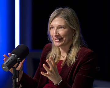 a person sitting at a desk with a microphone