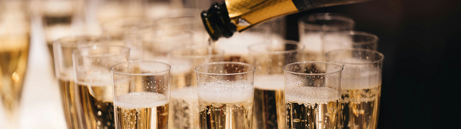 a champagne being poured into a group of glasses