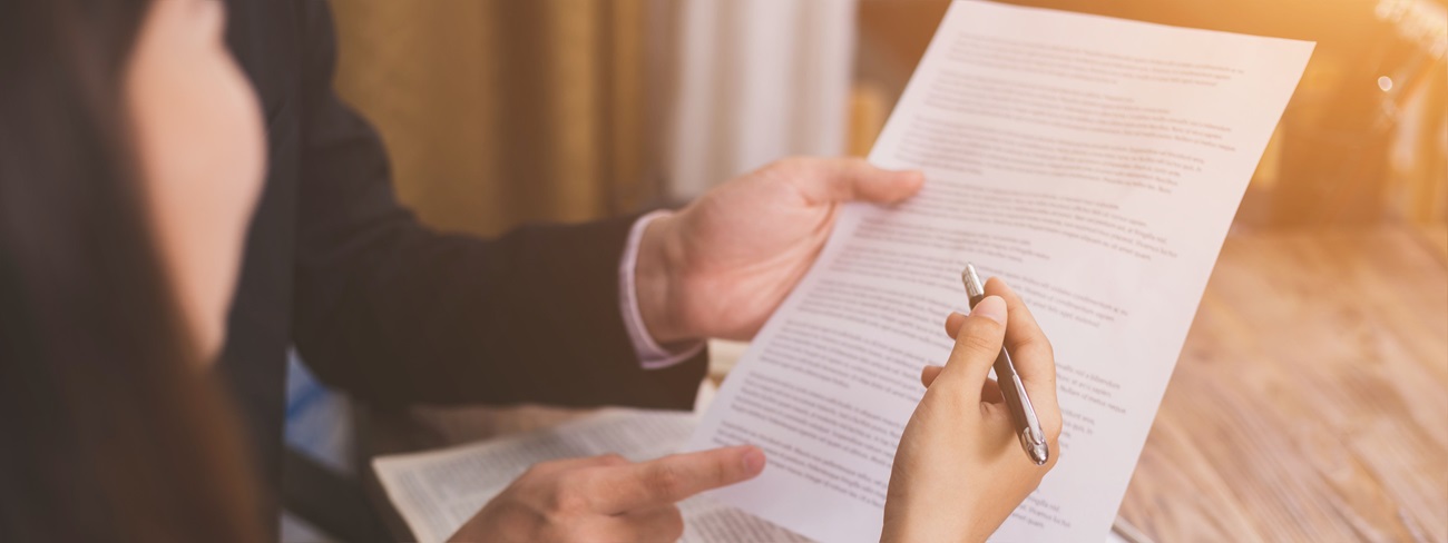 Person holding pen near paperwork