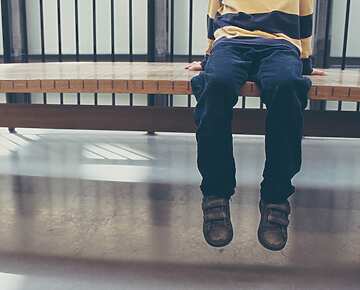 child waiting on bench