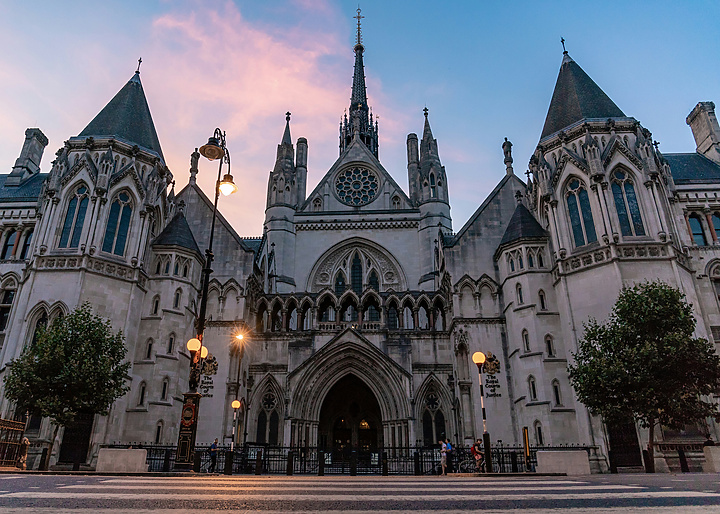 a large building with a spire with Royal Courts of Justice in the background