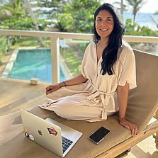a person sitting on a chair with a laptop and phone