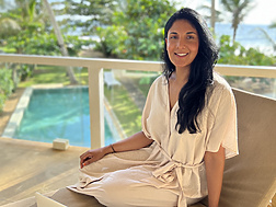 a person sitting on a chair with a laptop and phone
