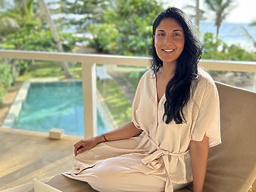 a person sitting on a chair with a laptop and phone