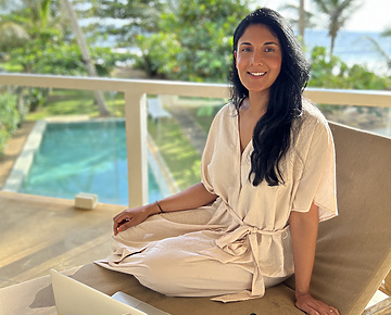 a person sitting on a chair with a laptop and phone