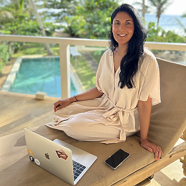 a person sitting on a chair with a laptop and phone