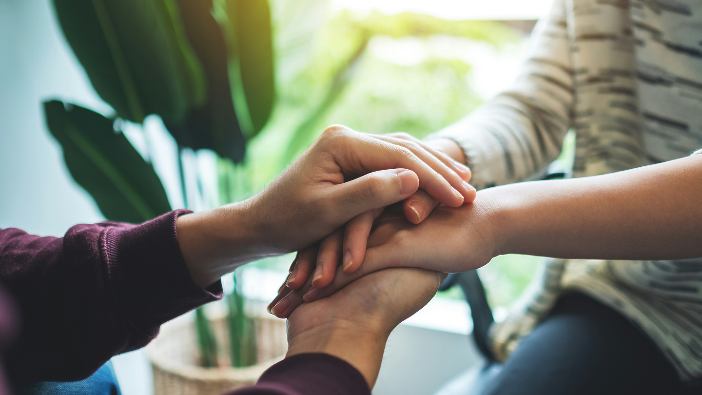 a close-up of hands holding each other